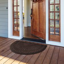 bruin, halfrond, 60 x 90 cm Deurmat van gerecycled rubber, halfrond, geplaatst voor een open voordeur.