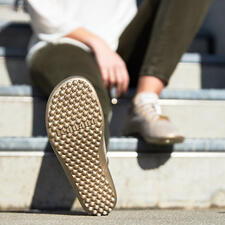 goud Zool van een Barfuß-leguano Sneaker in beige, op de voorgrond.