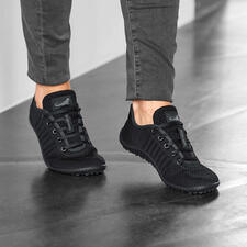 zwart Barfuß-leguano Sneaker in zwart, gedragen door een persoon.