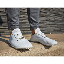 wit Persoon in grijze joggingbroek draagt witte Barfuß-leguano® sneakers op beton.