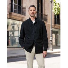 Overhemdjasje van rendierkalfsleer Man in een zwarte rendierkalfsleder hemdjack, staand voor moderne architectuur in de stad.