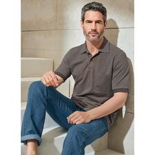 taupe Man zit op een trap in een donker poloshirt en blauwe jeans.