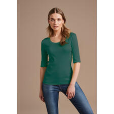 groen Vrouw in groen Wolff-shirt met 3/4 mouwen poseert voor een neutrale achtergrond