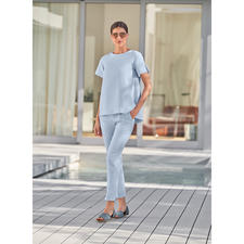 blauw Vrouw in lichte outfit toont Apple of Eden kruisband sandals.