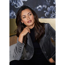 zwart/grijs Close-up van de vrouw in een fluwelen blazer met houndstooth patroon.