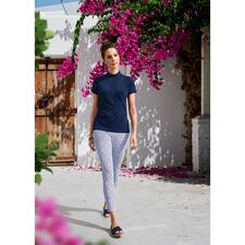 donkerblauw Vrouw in een marinekleurige Clark Ross korte mouwen trui in een zonnige omgeving.