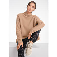 beige Vrouw in beige trui en lamsvellen sneakers