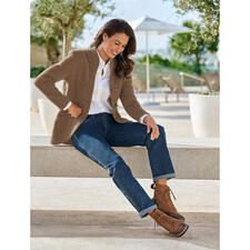 bruin Vrouw in een bruine Softwalk-jack van Mirabell, ontspannen op een stenen bank.