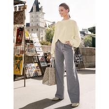 ecru Dames trui in lichtgeel, los en casual met grijze broek.