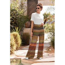 broek Vrouw in IVKO jacquard combinatie zit aan het water met een zonnebril.