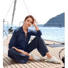 arche comfort-sneakers Vrouw in een polo-cardigan zit ontspannen op de boot.