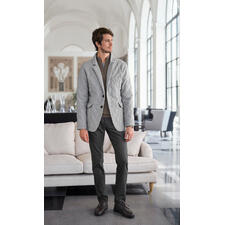 Schipperstrui van kasjmier-piqué Man in een grijze kasjmier gewatteerde jas in een elegante interieur.