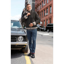 OCONI B3-pilotenjack van lamsvacht Man in schapenvacht pilotenjack poseert naast een klassieke auto