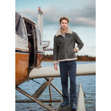 OCONI B3-pilotenjack van lamsvacht Man in bruine B3 schapenvacht pilotenjacke staat naast een vliegtuig.