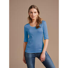 jeansblauw Blauw Wolff-shirt, vrouwelijke model op neutrale achtergrond.