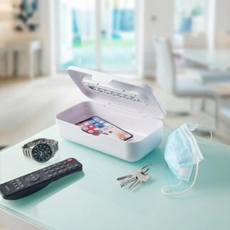 UV-C-straalsterilisator 2-in-1 met smartphone en dagelijkse voorwerpen op een tafel.