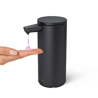 Zwart sensorzeepdispenser geeft zeep op een hand.