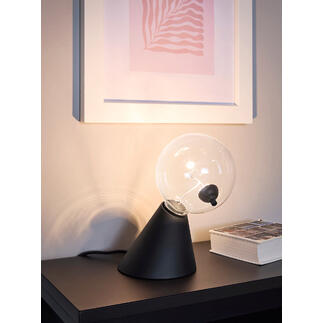 Tafel lamp Satellite met heldere glazen bol en zwarte voet op een plank.