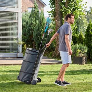 Man trekt een opvouwbare tuintrolley met bladeren door de tuin.