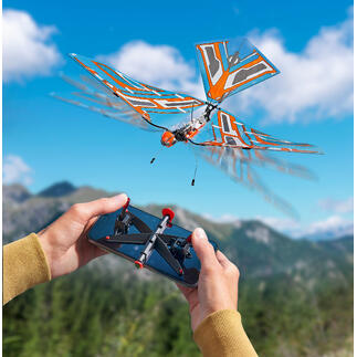 Afstandsbediend model van een vliegend insect met een oranje vleugelstructuur.