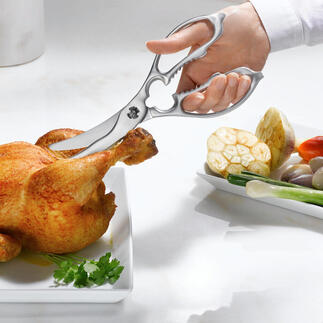 Twee-in-een keuken- en gevogelschaar snijdt een kip op een bord.