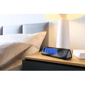 Radio-alarmklok met LED-zaklamp op nachtkastje naast bed