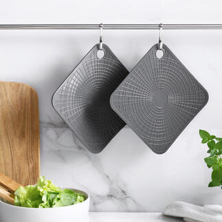 Twee grijze silicone ovenwanten hangen aan een stang in een moderne keuken.