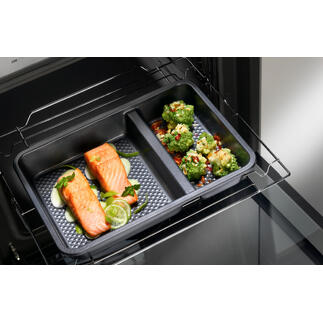 Twee-delige ovenschaal met zalm en groenten in de oven