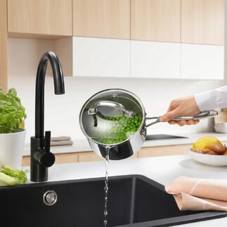 Steelpan met deksel, water wordt in de gootsteen gegoten.