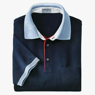 Donkerblau polo met lichte blauwe kraag, gevouwen op een witte achtergrond.