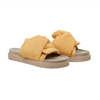 Geel knoop-slipper van Inuikii, zijaanzicht op een neutrale achtergrond.