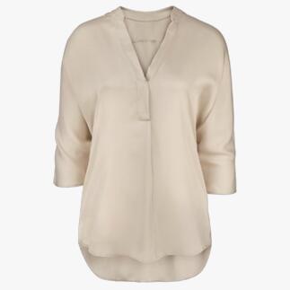 Beige tuniek blouse met V-hals en lange mouwen op een witte achtergrond.
