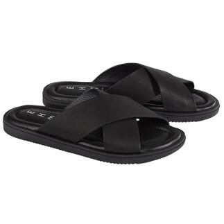 Paar zwarte leren slippers op een witte achtergrond