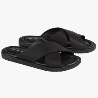 Paar zwarte leren slippers op een witte achtergrond