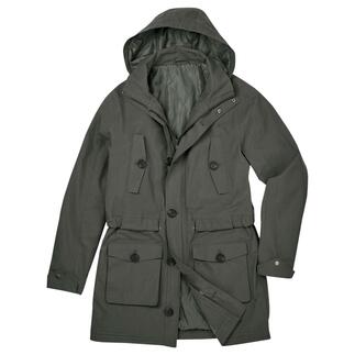 Olijfgroene parka met open capuchon op de tafel.