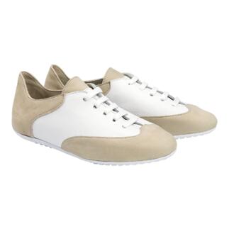 Beige en witte comfortabele sneakers op een neutrale achtergrond, van voren bekeken.