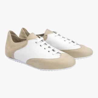 Beige en witte comfortabele sneakers op een neutrale achtergrond, van voren bekeken.