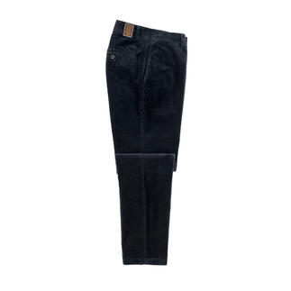 Zwarte fluwelen broek, liggend op een tafel met open zakken.