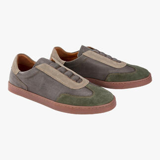 Twee grijze OCONI slip-on schoenen met groene accenten op een lichte achtergrond.