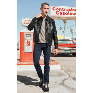 Man in zwarte kalbnappa-softjacke en beige pullover voor een tankstation.