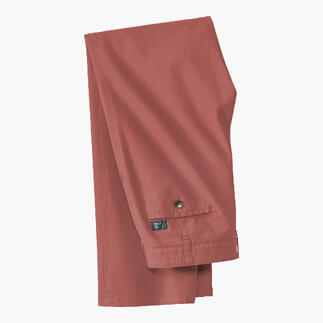 Perzikkleurige canvas broek op een witte achtergrond gevouwen.