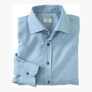 Opgevouwen DU4 kasjmier-flanel shirt in lichtblauw op een tafel.