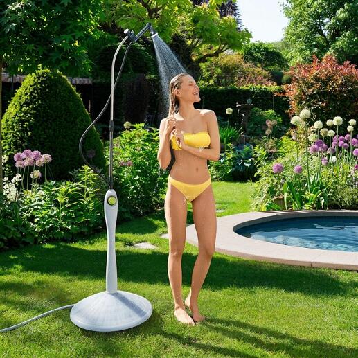 Vrouw in een gele bikini die onder de Sunny Premium zonne-douche in de tuin staat.