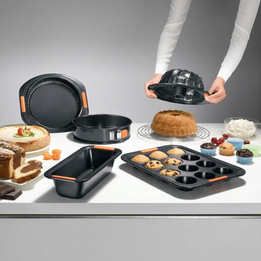 Le Creuset anti-aanbakvormen op een tafel met cake en koekjes.