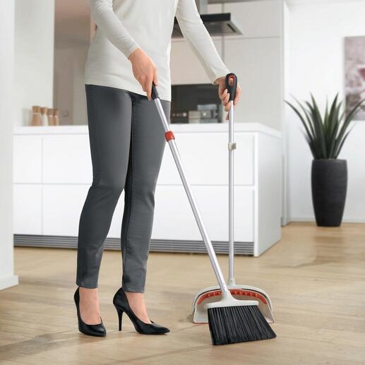 Vrouw met uitschuifbare bezemveger veegt de vloer