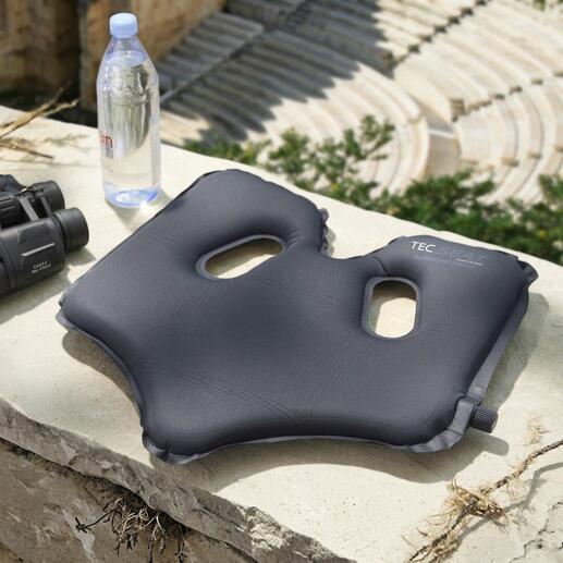 Comfortabele SoftAirSeat op een steen met een waterfles en verrekijker.