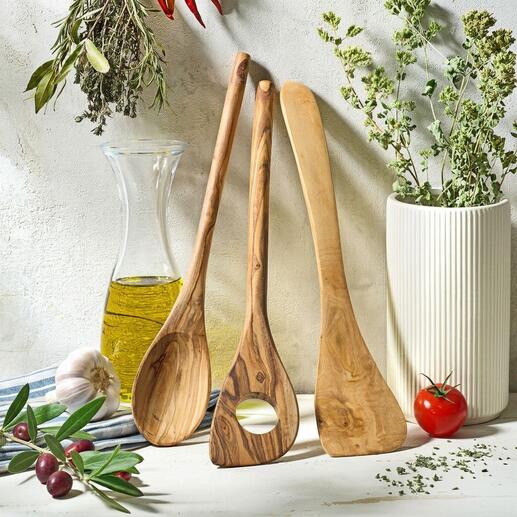 Drie-delig olijfhouten keukengerei op een rustieke tafel met kruiden.