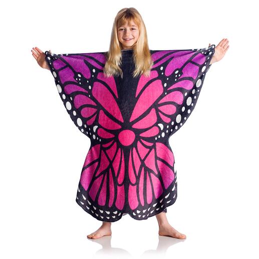 Meisje in poncho met vlinderontwerp in roze en zwart op een lichte achtergrond.