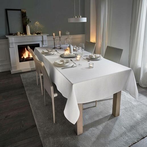 Witte tafel met feestelijk tafelkleed in linnenlook en kaarsen.