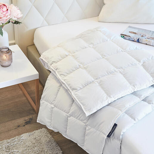 Lichte eiderdeken op een bed met kussens